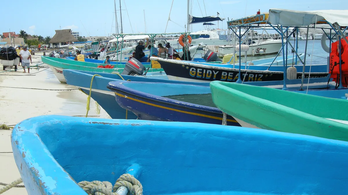 Barcos de pesca coloridos na areia de Playa del Norte, em Isla Mujeres