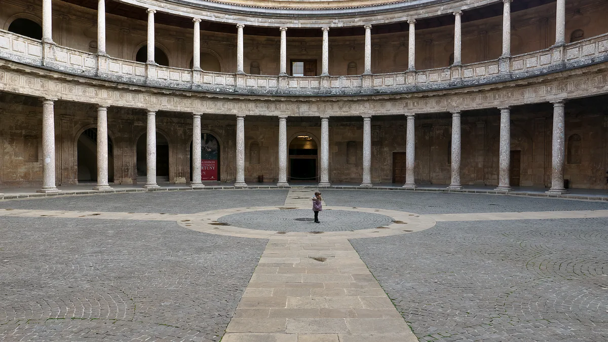 O pátio circular do Palacio de Carlos V, na Alhambra, com as duas ordens de colunas e uma pessoa ao centro