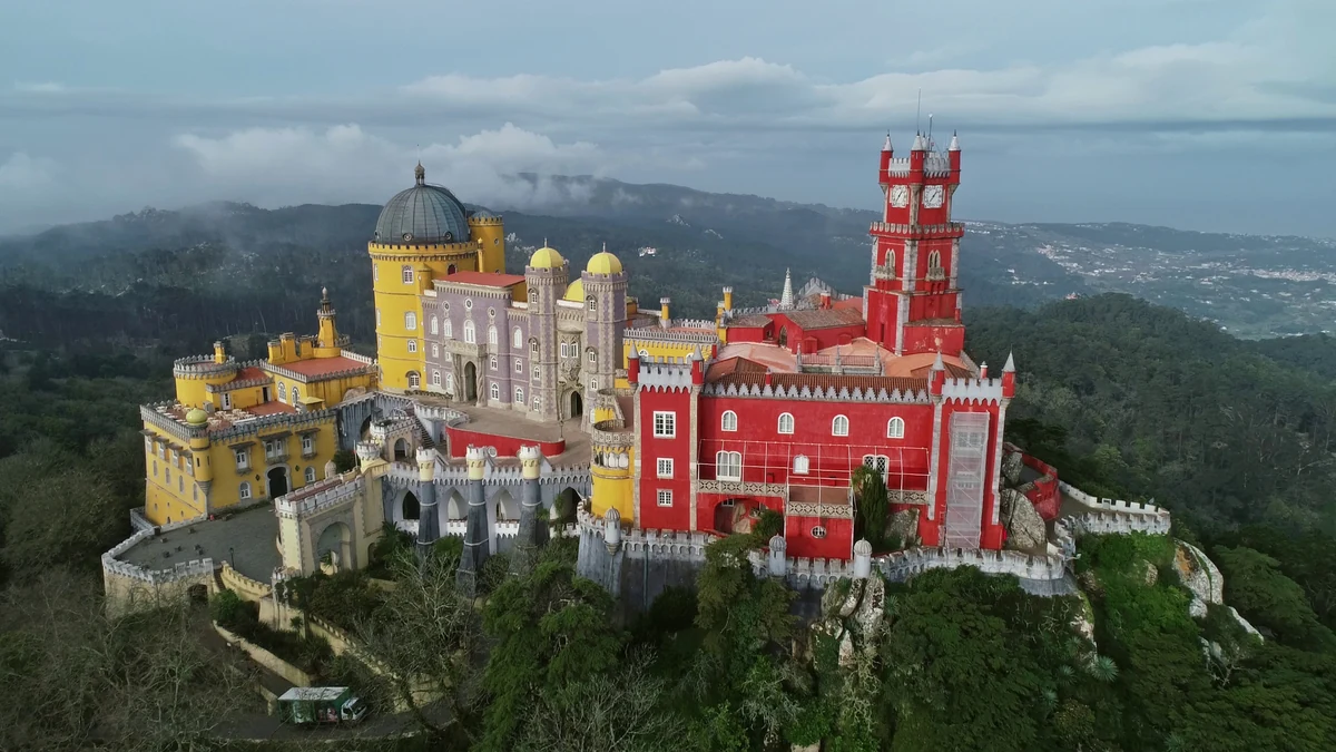 Palácio Nacional da Pena visto do alto, com as alas vermelha e amarela sobre a serra de Sintra