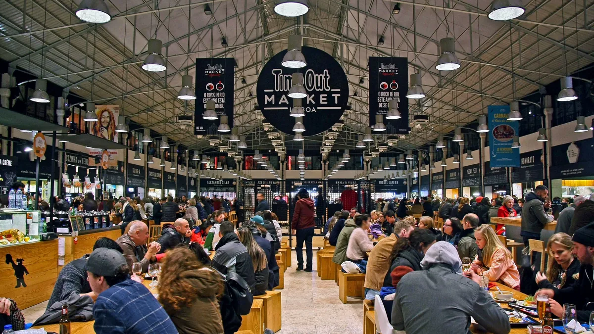 Salão do Time Out Market, no Mercado da Ribeira, com as mesas comunitárias cheias