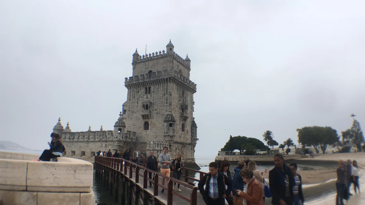 Torre de Belém sobre o Tejo, com visitantes no passadiço de acesso