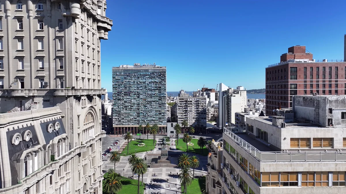 Vista aérea da Plaza Independencia em Montevidéu, com a pedra do Palacio Salvo à esquerda e o Rio da Prata ao fundo