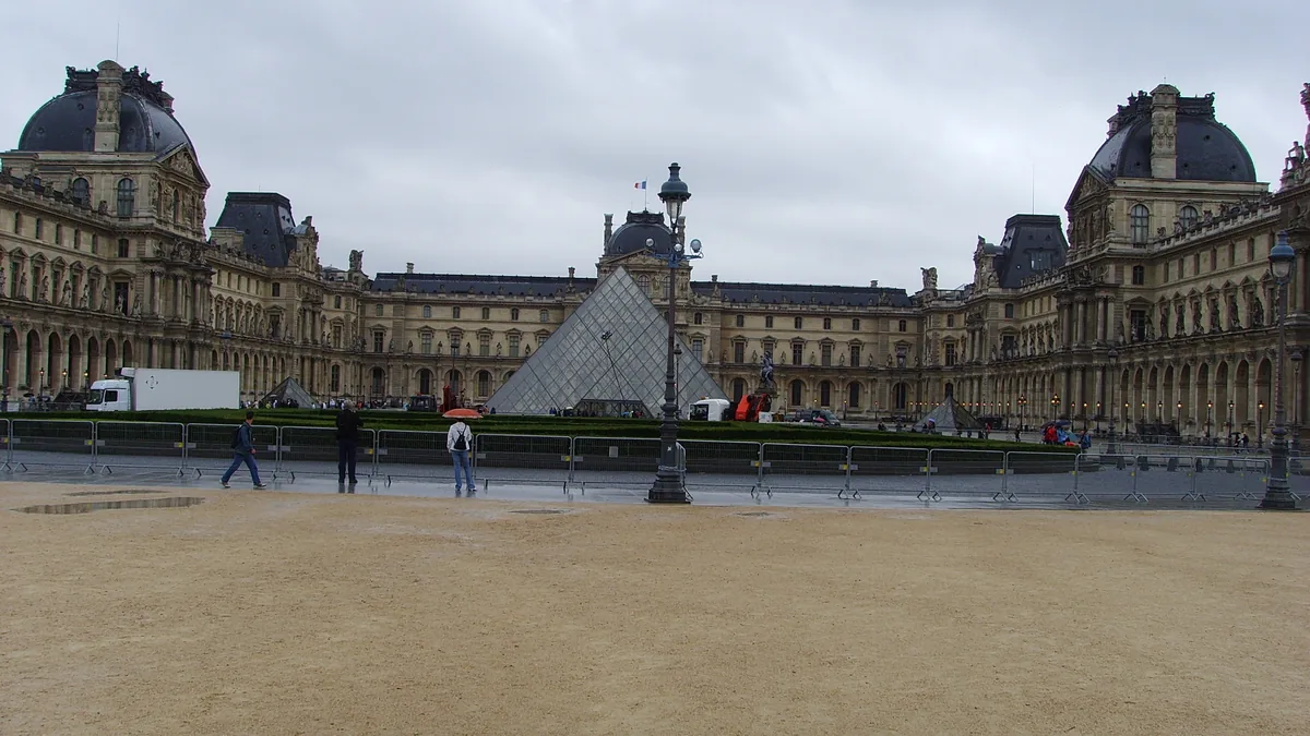 A pirâmide de vidro do Louvre no centro da Cour Napoléon, com as alas do palácio em volta