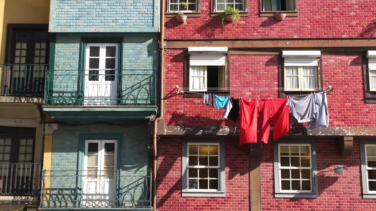 Fachadas estreitas e coloridas da Praça da Ribeira, com roupa estendida nas janelas