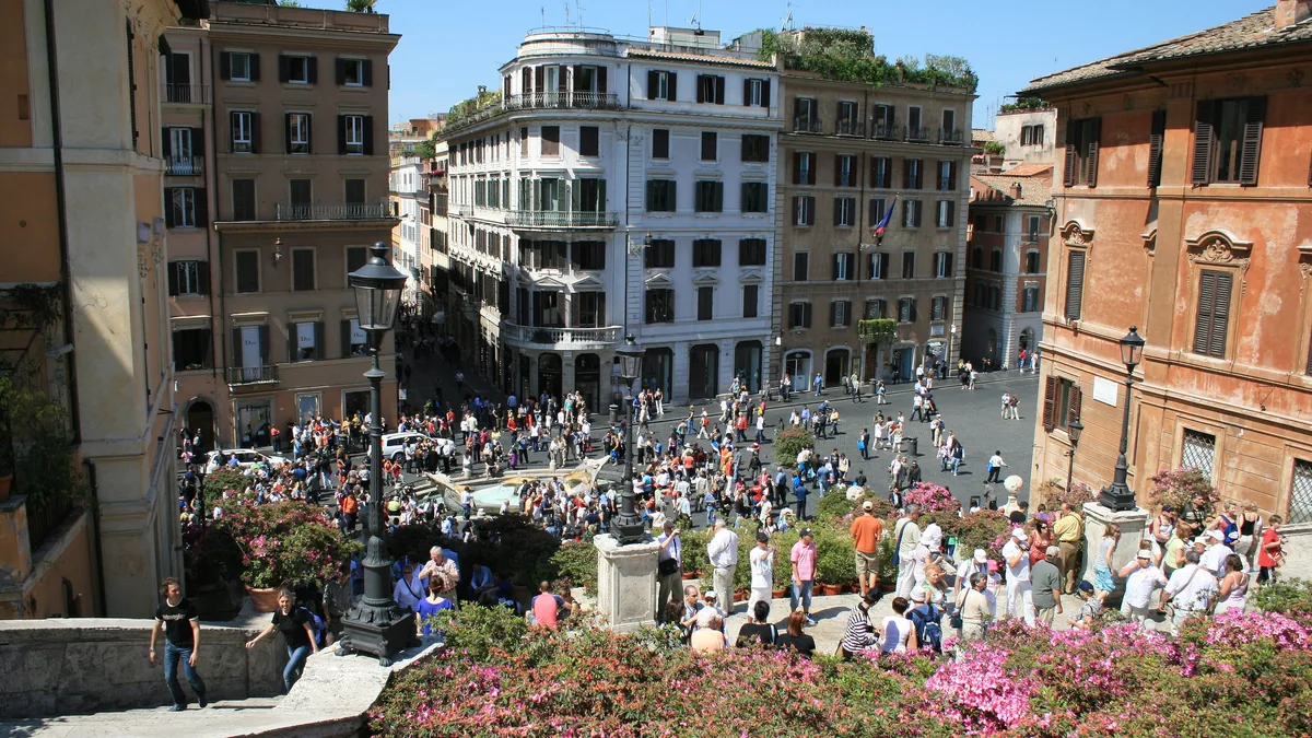A escadaria de Trinità dei Monti vista de cima, com as azaleias nos degraus e a Piazza di Spagna cheia ao pé