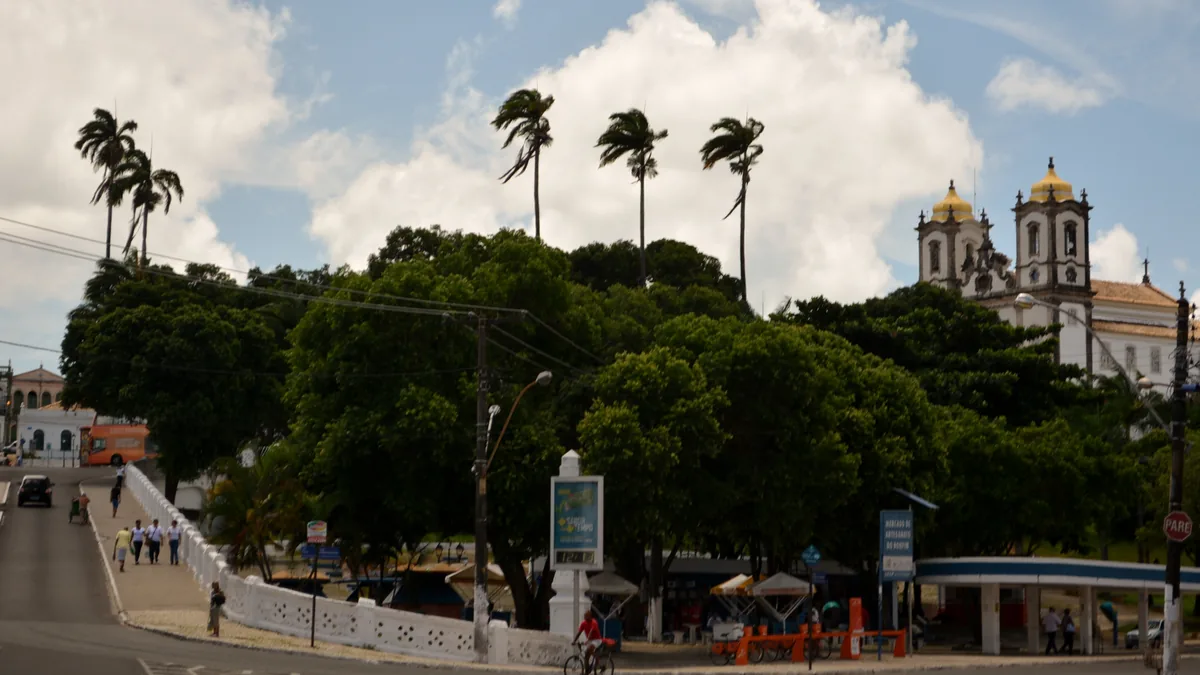 A Basílica do Senhor do Bonfim vista do largo, com as duas torres claras despontando acima das árvores