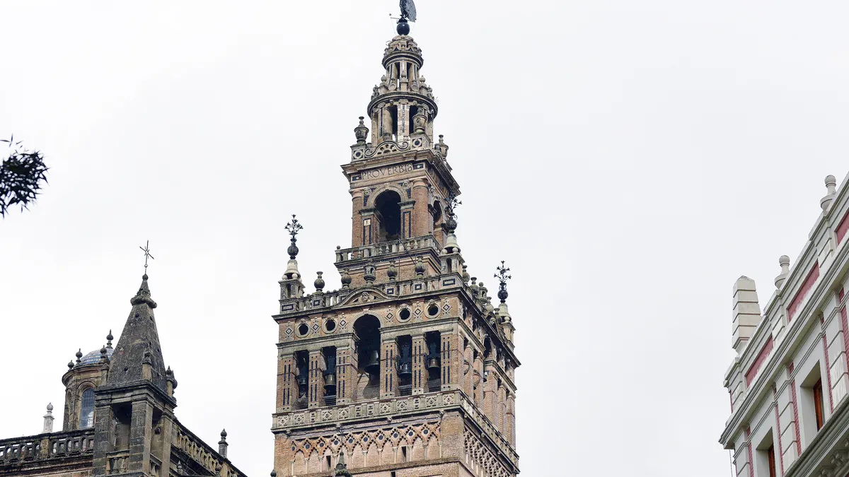 A Giralda vista de baixo, com o campanário renascentista sobre a torre almóada e os pináculos góticos da catedral na base